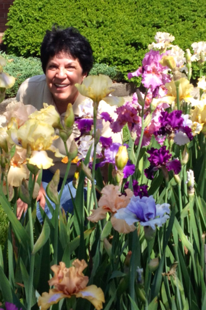 a woman standing behind flowers and smiling