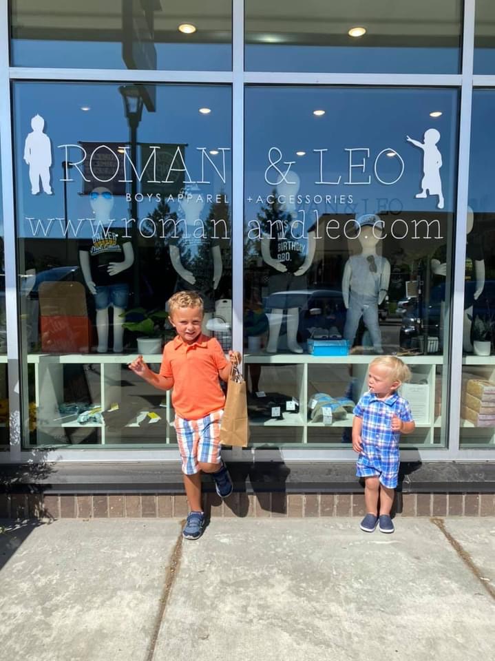two boys standing outside of a store