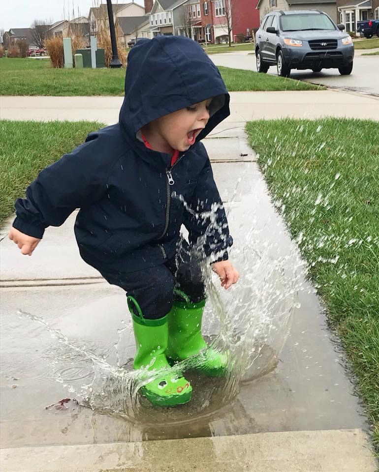 boy jumping in puddles