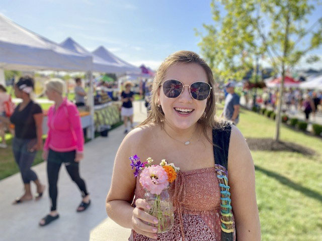 woman holding flower at farmers market
