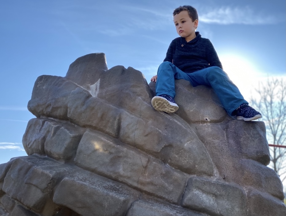 boy sitting on rock