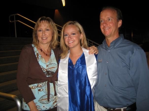 kelly yale posing with her parents at her high school graduation