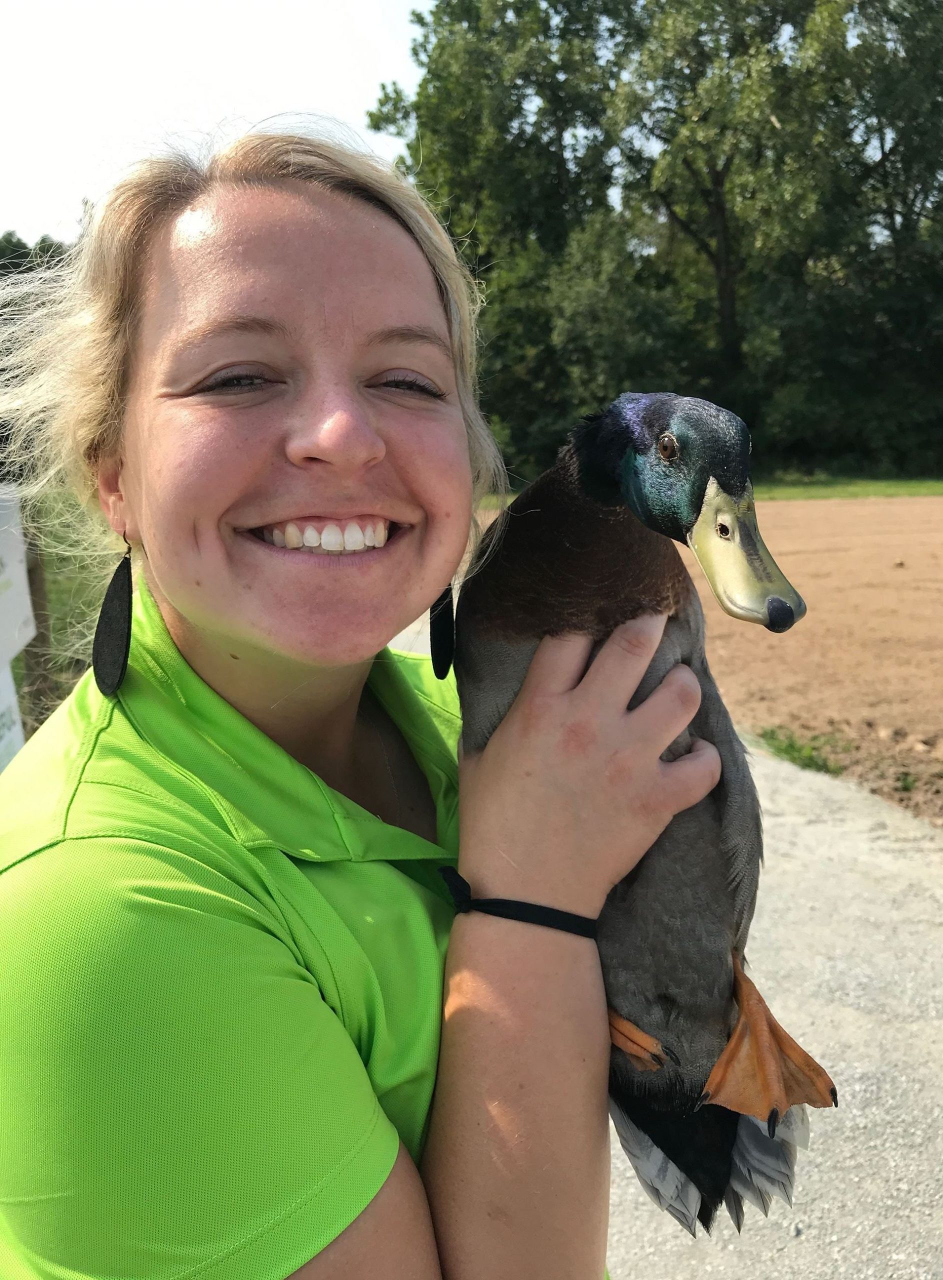 a woman smiling and holding a duck