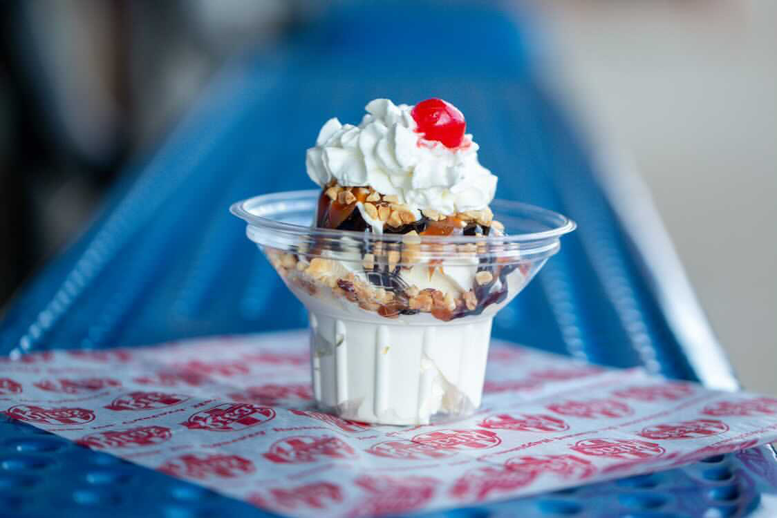 a vanilla hot fudge sundae with whipped cream and cherry
