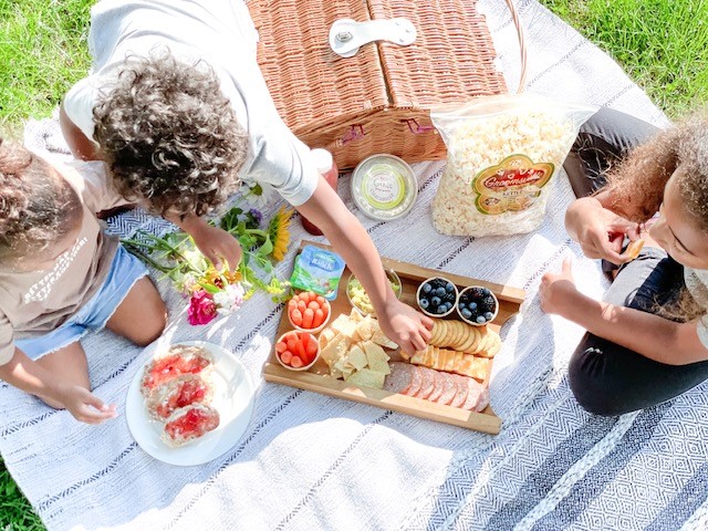 an aerial view of three kids sitting and eating a picnic