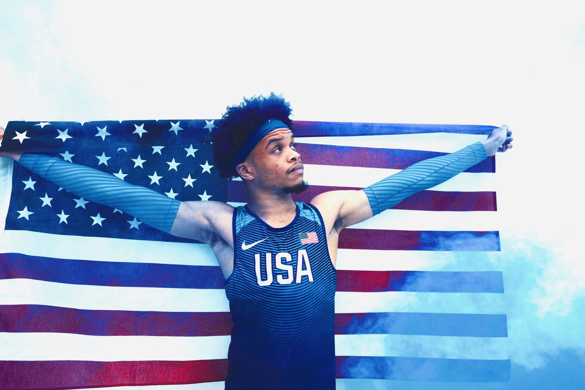 a man in a track uniform holding the american flag