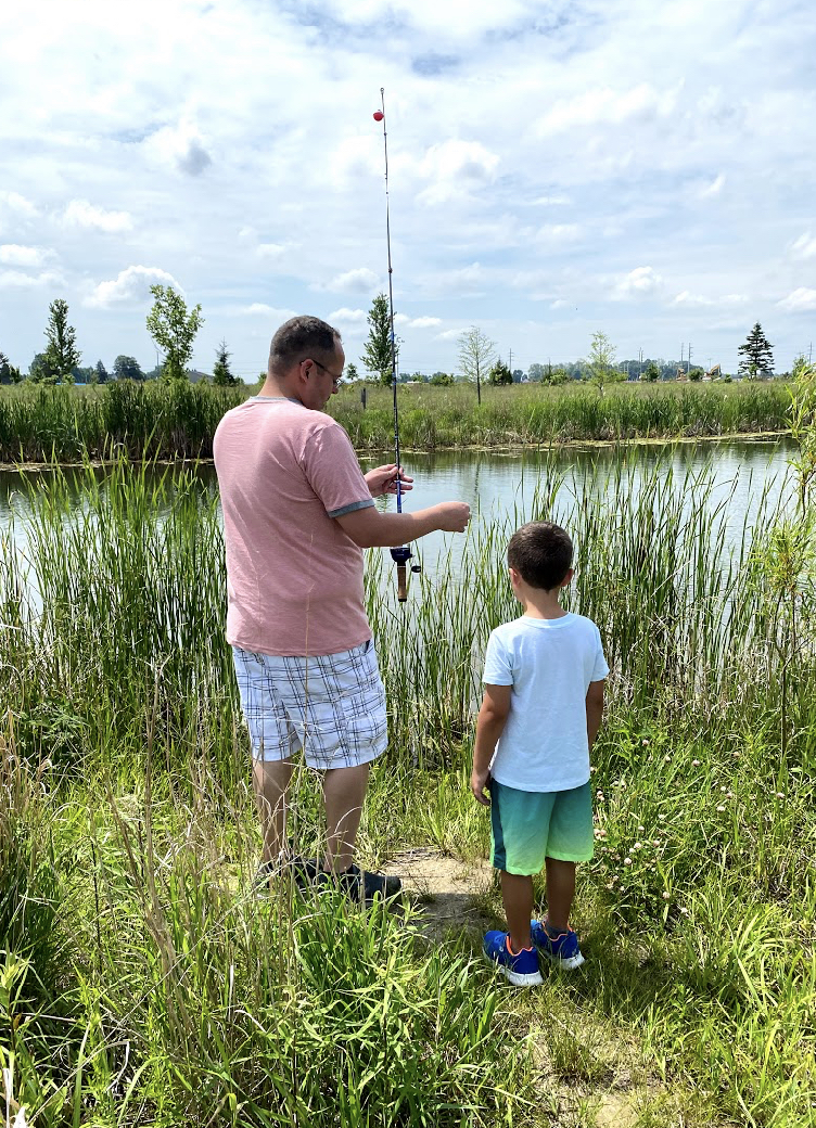 a dad showing his young son how to fish