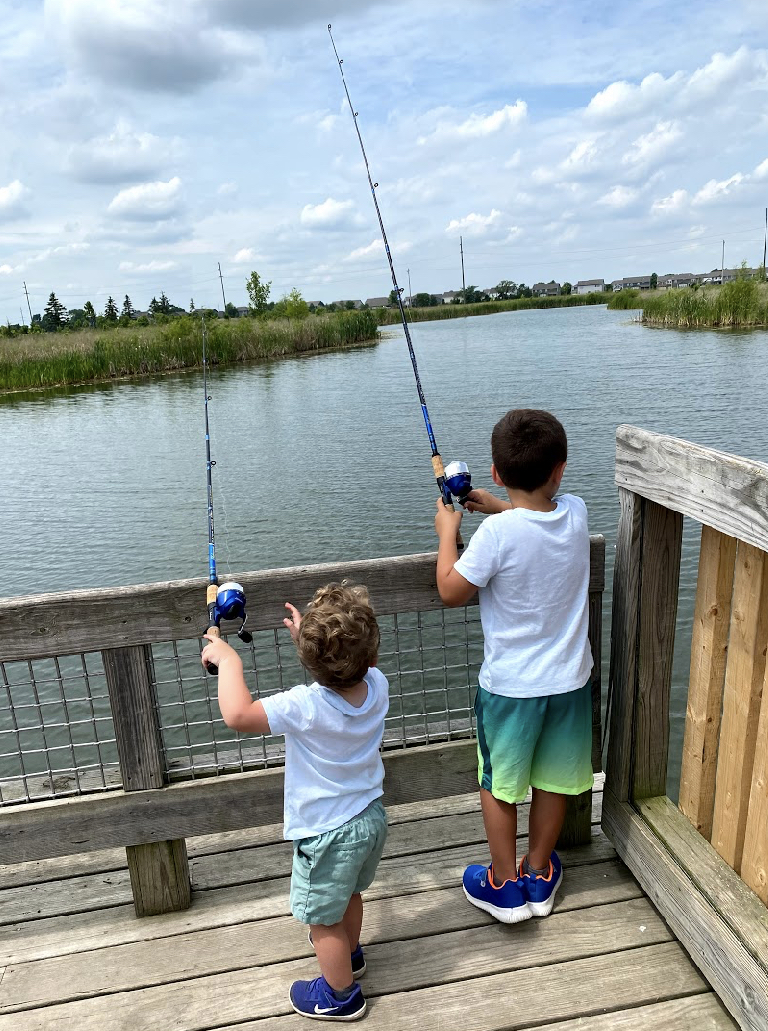 the back of two young kids fishing