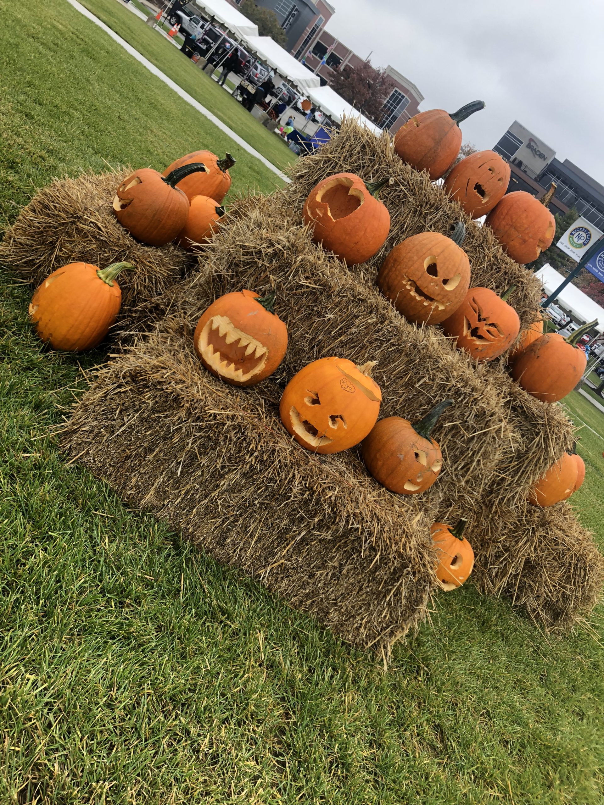a pile of carved pumpkins on top of hay barrels