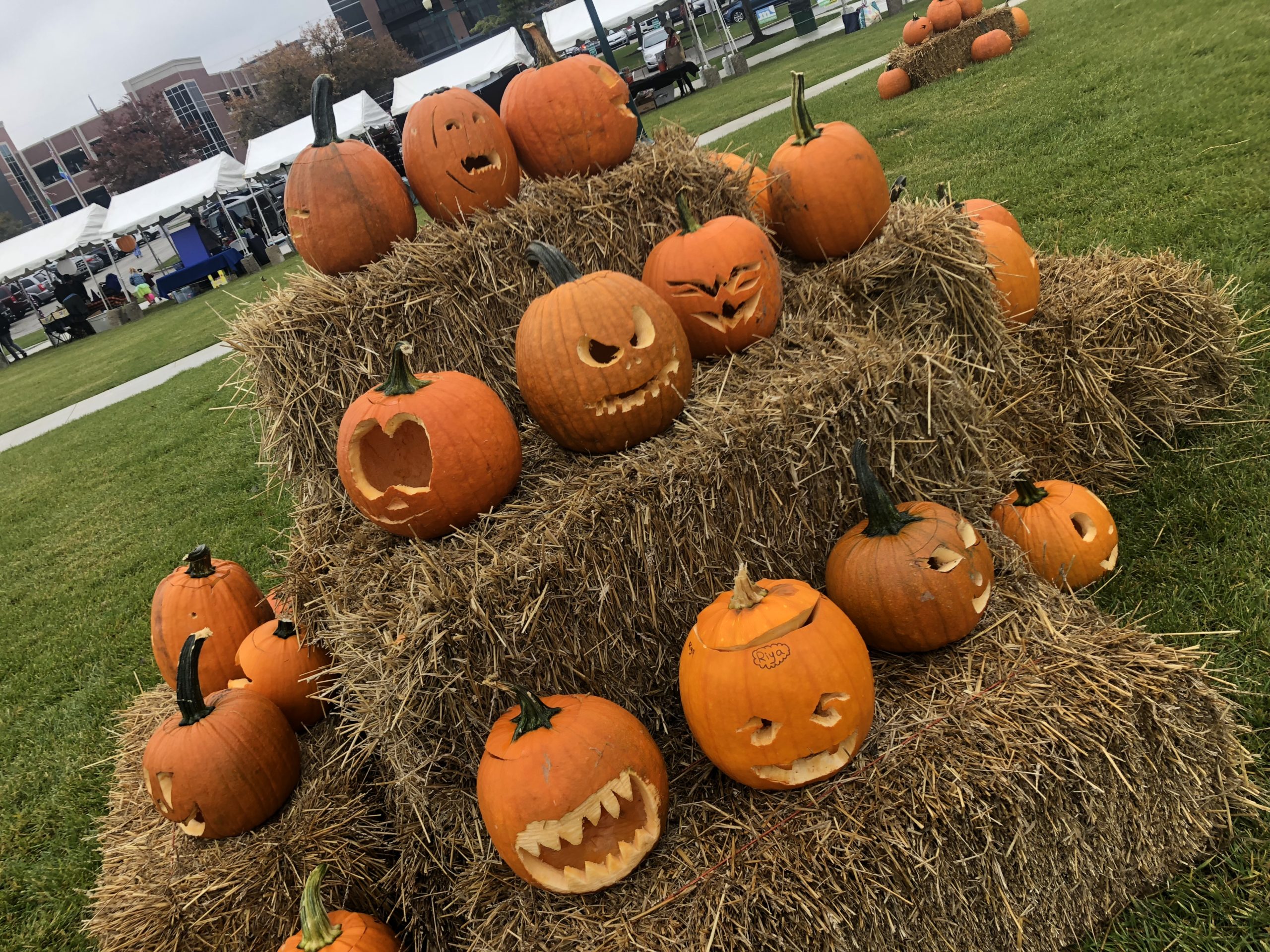 carved pumpkins stacked on top of hay