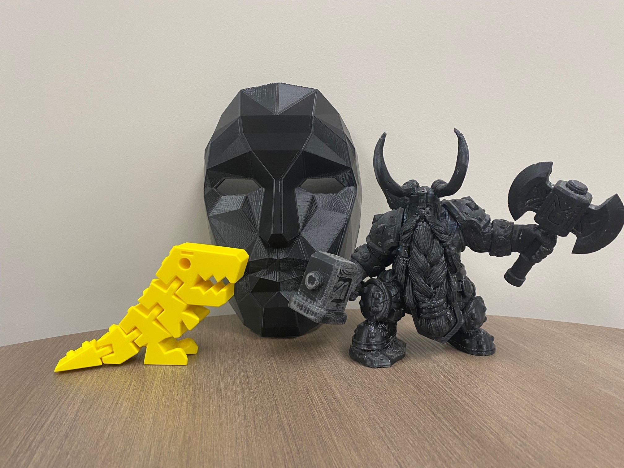 a yellow dinosaur, black mask, and character with horns