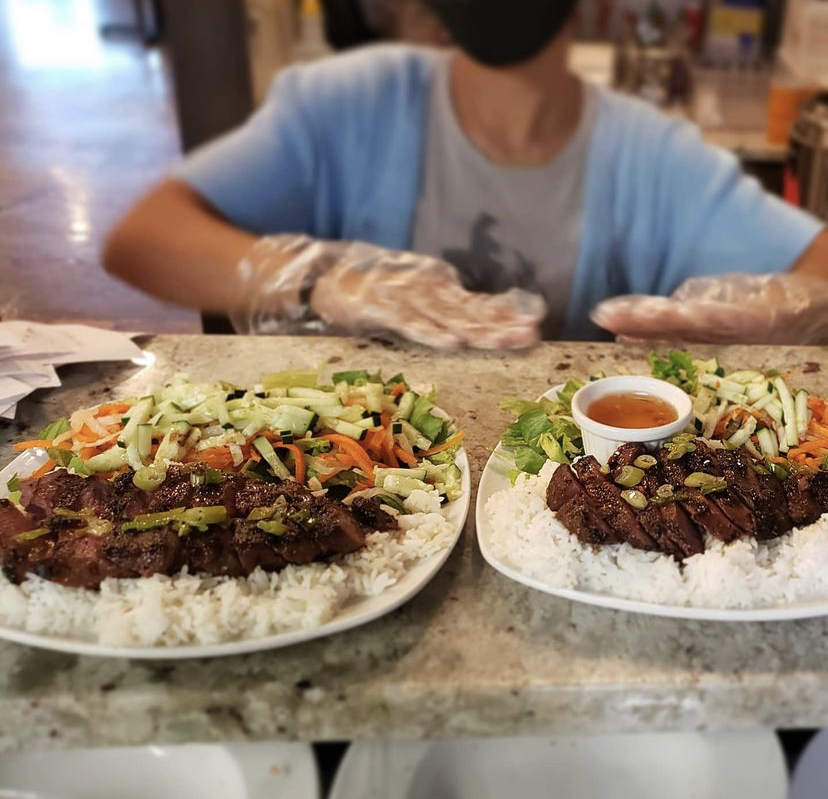 two plates of food with rice, veggies, meat and sauce
