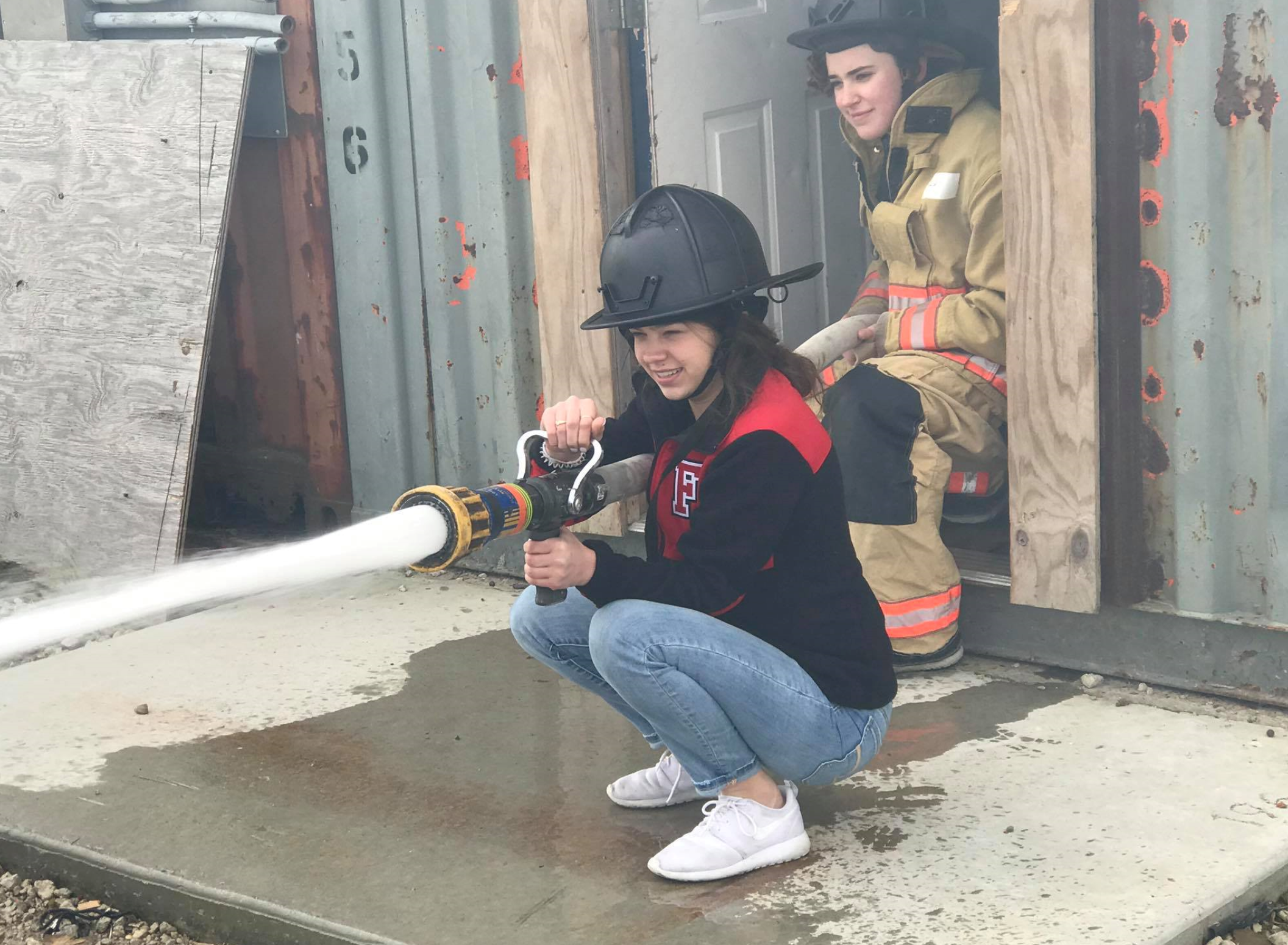Young girl using fire department hose