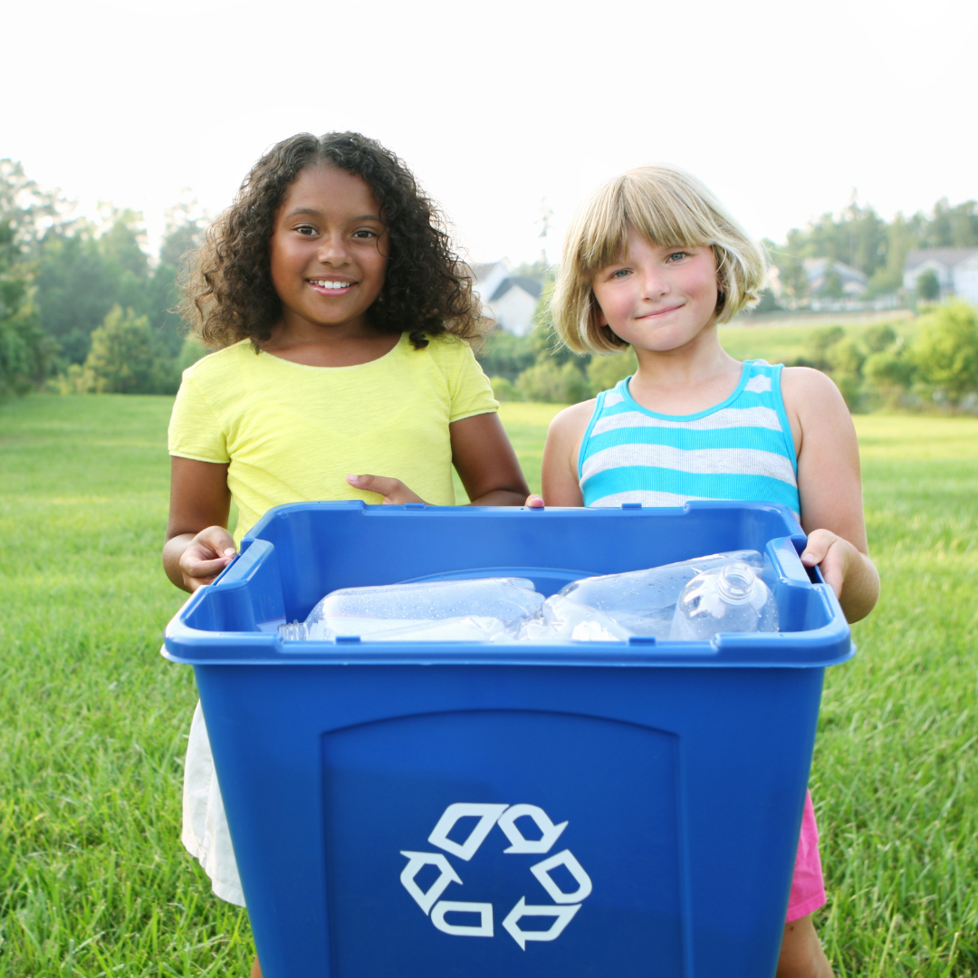 2 girls holding recycling bin